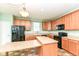 Kitchen with appliances, wooden cabinets, and an extended countertop for seating at 15946 Marsala Dr, Fishers, IN 46037