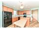 Well-lit kitchen featuring wooden cabinets, black appliances, and a spacious layout at 15946 Marsala Dr, Fishers, IN 46037