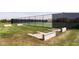 A community tennis court behind a tall fence with horseshoe pits in the foreground at 15946 Marsala Dr, Fishers, IN 46037
