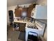 A partial view of a kitchen with wood cabinets, appliances and a pass-through window to another room at 1768 N Lynhurst Dr, Speedway, IN 46224