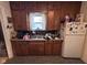 A functional kitchen featuring wooden cabinets, a stainless steel sink, and appliances at 1768 N Lynhurst Dr, Speedway, IN 46224