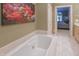 Relaxing soaking tub with a view of the bedroom featuring decorative floral artwork at 1870 Broadleaf Ct # 10, Greenwood, IN 46143