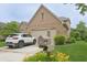 Beautiful brick home with a two-car garage, lush landscaping, and a white SUV parked in the driveway at 1870 Broadleaf Ct # 10, Greenwood, IN 46143