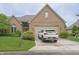 Charming brick home featuring a well-manicured lawn, lush shrubbery, and a two-car garage with car in the driveway at 1870 Broadleaf Ct # 10, Greenwood, IN 46143