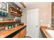 Bathroom with wooden accents, a white door, shelving, and a sink at 2020 Treving Dr, Cicero, IN 46034