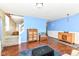Spacious living room with hardwood floors, a cozy blue accent wall, and staircase access at 2020 Treving Dr, Cicero, IN 46034