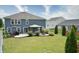 The spacious backyard features a covered patio, fire pit, and lush green grass at 21491 Raccoon Ct, Noblesville, IN 46062