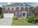 Inviting brick home featuring a well-maintained lawn, lush landscaping, and an attached two-car garage at 21491 Raccoon Ct, Noblesville, IN 46062