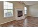 Living room boasting a decorative fireplace, white mantle and hearth, natural light, and modern wood floors at 21491 Raccoon Ct, Noblesville, IN 46062
