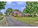 Quaint brick home featuring a covered porch, well-maintained yard, and driveway at 241 Wehmeier St, Columbus, IN 47201