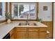 Bright kitchen featuring a stainless steel sink with garden window and wooden cabinets at 241 Wehmeier St, Columbus, IN 47201