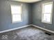 Comfortable bedroom features neutral carpet and two bright windows at 2507 S Keystone Ave, Indianapolis, IN 46203