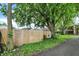 Backyard view of a wood fence separating the yard from neighboring buildings and lush green trees at 26 E Plum St, Anderson, IN 46012