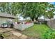 Large backyard featuring a concrete patio, mature trees, and a playground set at 26 E Plum St, Anderson, IN 46012