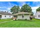 Charming single-story home with green siding, well-maintained lawn, and mature trees at 26 E Plum St, Anderson, IN 46012