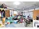 Cluttered garage featuring two dirt bikes, tools, storage, and overhead door opener at 26 E Plum St, Anderson, IN 46012