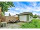 Outside view of a detached one-car garage with vinyl siding and a trailer on a gravel drive at 26 E Plum St, Anderson, IN 46012