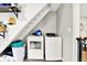 Laundry area under the staircase, featuring a washer and dryer at 26 E Plum St, Anderson, IN 46012