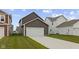 Spacious two-car garage with a long driveway, exterior lighting, and well-maintained lawn at 2733 Lamar Dr, Whitestown, IN 46075