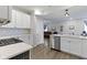 Bright kitchen featuring white cabinets, a stainless steel dishwasher, and view to the living space at 2733 Lamar Dr, Whitestown, IN 46075
