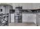 The modern kitchen includes stainless steel appliances, white cabinetry, granite countertops, and sleek tile backsplash at 2734 Newaygo Dr, Indianapolis, IN 46217