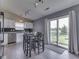 Well-lit kitchen with black splash-tile, bright white cabinets, stainless appliances and a breakfast table at 2734 Newaygo Dr, Indianapolis, IN 46217