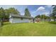 Picture of the back exterior of a house, with a fenced yard, patio with chairs, and grass at 3019 E Berwyn St, Indianapolis, IN 46203