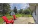 Backyard featuring a concrete patio with red Adirondack chairs, a wooden bench, and a storage shed at 3019 E Berwyn St, Indianapolis, IN 46203