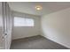 Bedroom featuring gray carpet, a window, and a closet with bi-fold doors at 3019 E Berwyn St, Indianapolis, IN 46203