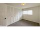 Bedroom featuring beige carpet, a window, and a closet with bi-fold doors at 3019 E Berwyn St, Indianapolis, IN 46203