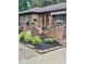 Close up of a brick home featuring a seating area on the front porch with potted plants at 3130 Taylor Rd, Columbus, IN 47203