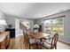 Cozy dining room with wood floors, a neutral color scheme, bright windows, and a view of the home's staircase at 317 Virginia St, Fortville, IN 46040