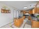 Well-lit kitchen showcasing oak cabinets, stainless steel appliances, tile floors, and island for extra counter space at 317 Virginia St, Fortville, IN 46040