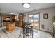 Light-filled kitchen boasts oak cabinets, a breakfast bar, a stainless fridge, and sliding glass doors to the backyard at 317 Virginia St, Fortville, IN 46040