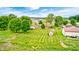Aerial view highlights a home with an expansive backyard, shed, basketball court, and surrounding green landscape at 333 N Windswept Rd, Greenfield, IN 46140