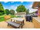 Outdoor living space with a wooden deck, dining area, relaxing seating, and well-maintained landscaping at 333 N Windswept Rd, Greenfield, IN 46140
