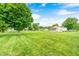 Expansive backyard with a lush lawn and mature trees, perfect for outdoor activities at 333 N Windswept Rd, Greenfield, IN 46140