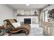 Warm interior with a cozy chaise lounge situated in front of a brick fireplace and mantel at 333 N Windswept Rd, Greenfield, IN 46140