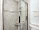 Tiled shower with glass doors, a built-in seat, and a built-in shower caddy at 333 N Windswept Rd, Greenfield, IN 46140