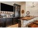 Basement bar with stone accents, dark cabinets and plenty of storage for all of your favorite beverages at 3675 Dartmoor Way, Zionsville, IN 46077