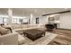 Open basement layout featuring a comfortable sectional sofa, wet bar, and dining area with wood-look flooring at 3675 Dartmoor Way, Zionsville, IN 46077