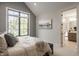 Cozy bedroom with natural light and a glimpse into the ensuite bathroom at 3675 Dartmoor Way, Zionsville, IN 46077
