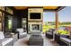 A covered patio featuring outdoor furniture, stone fireplace, TV, and golf course and water views at 3675 Dartmoor Way, Zionsville, IN 46077