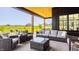 This outdoor patio features covered seating, open views of a golf course and pond, and a fire pit at 3675 Dartmoor Way, Zionsville, IN 46077