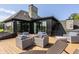 Modern deck area with comfortable outdoor seating and an elegant stone fireplace chimney at 3675 Dartmoor Way, Zionsville, IN 46077