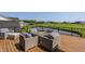 Outdoor deck with comfortable wicker furniture overlooking golf course and water feature at 3675 Dartmoor Way, Zionsville, IN 46077
