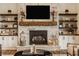 A stone fireplace with a dark screen and built-in storage and shelving on both sides at 3675 Dartmoor Way, Zionsville, IN 46077