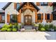 Close up of front entrance with glass paneled door, light stone accents and wood trim at 3675 Dartmoor Way, Zionsville, IN 46077