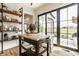 Open kitchen with an island, wood floors, open shelving, stainless appliances, and views of outdoor space at 3675 Dartmoor Way, Zionsville, IN 46077