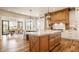 Bright kitchen island with wooden cabinetry, white countertops, and stylish pendant lighting at 3675 Dartmoor Way, Zionsville, IN 46077